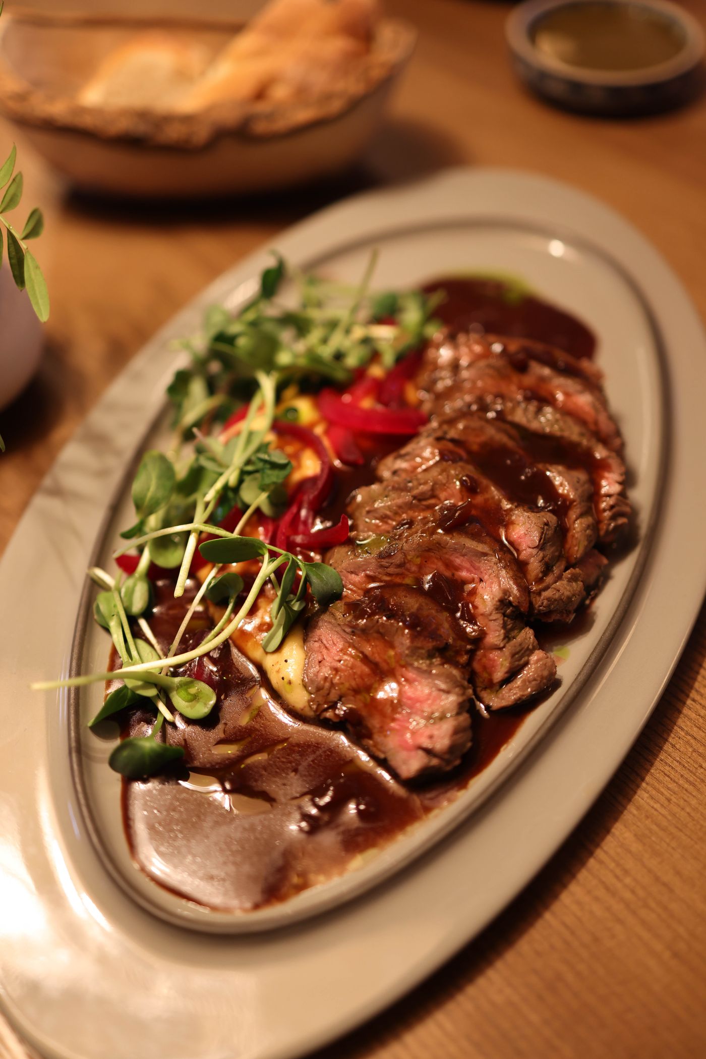 Ember-grilled steak plated with accompaniments, illustrative demo dish