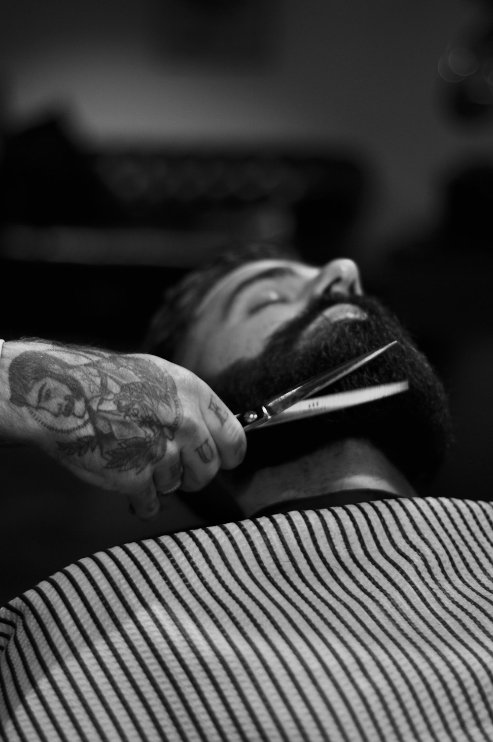 Barber trimming and shaping a full beard, illustrative demo image