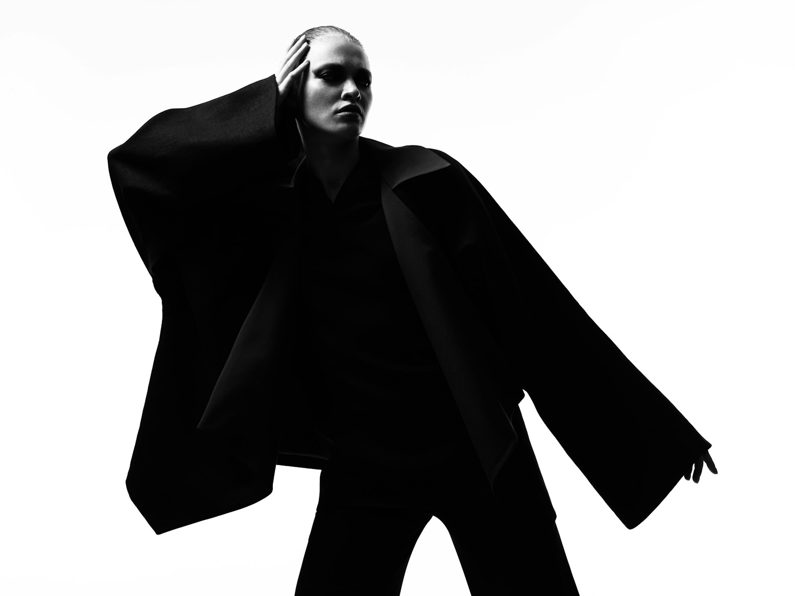 Monochrome editorial portrait of a model in an oversized black jacket