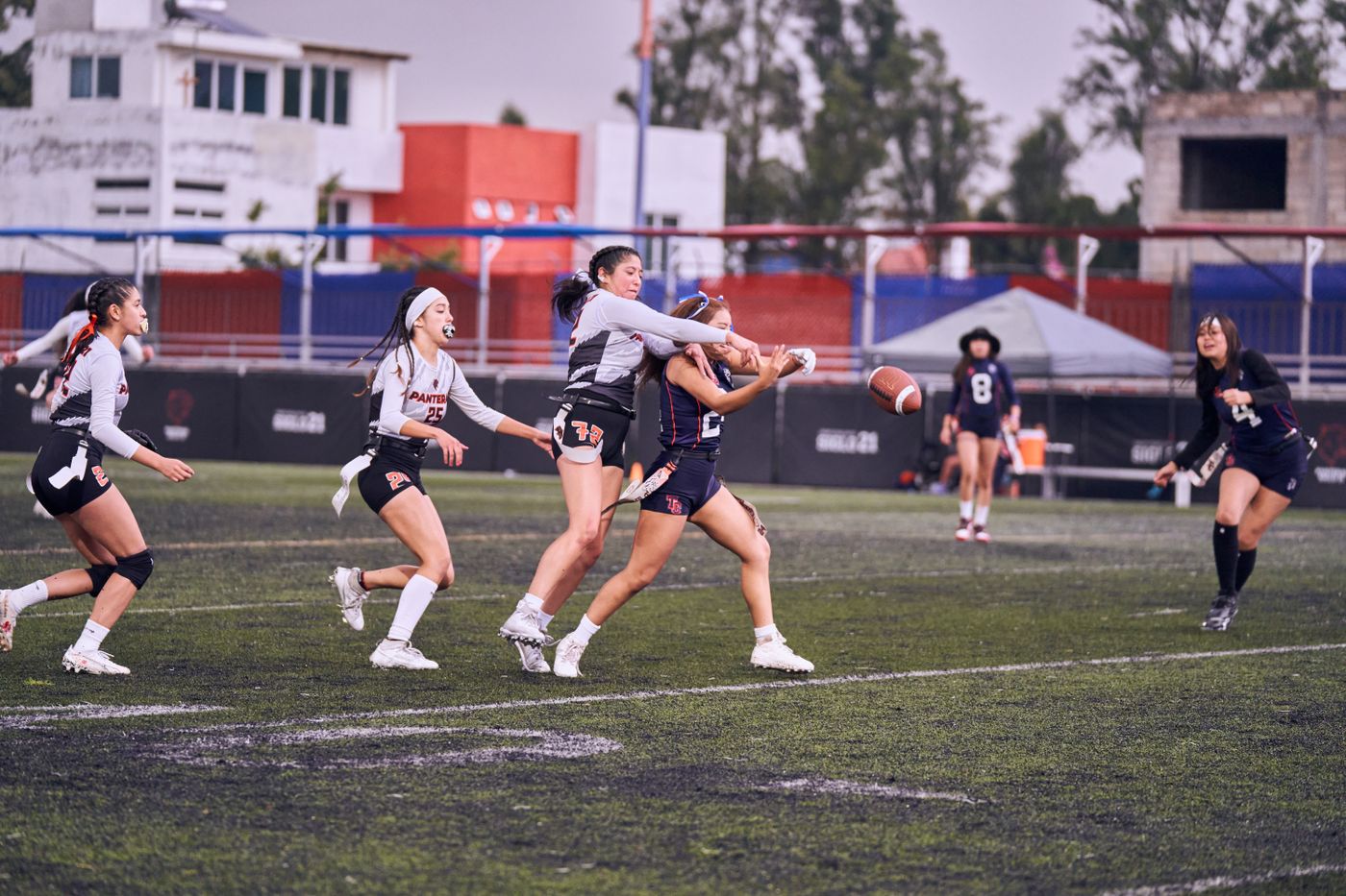 Women playing flag football in an outdoor game on a marked field